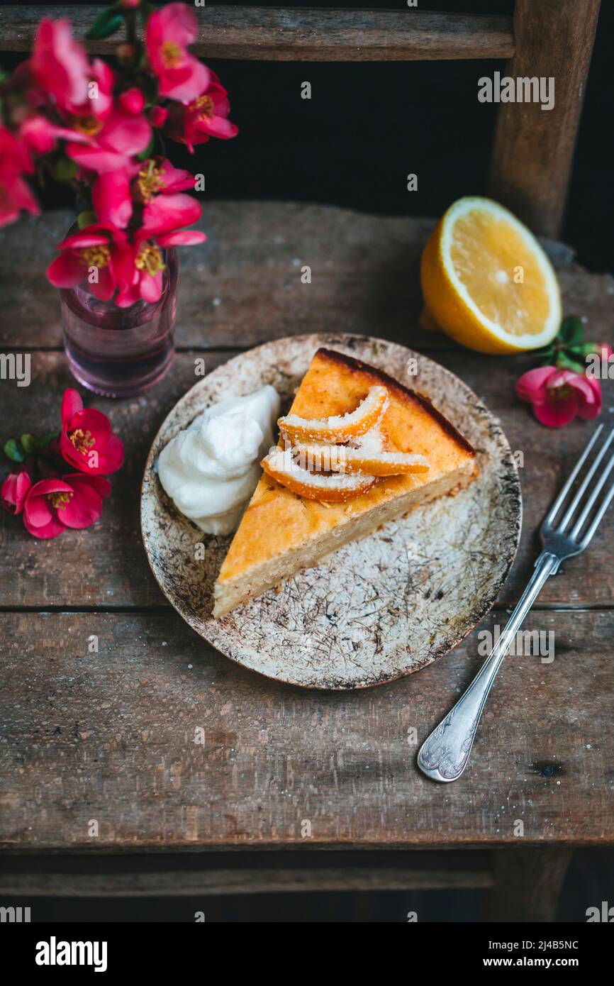 Tranche de gâteau à la ricotta au citron sur une assiette de dessert sur une chaise rustique vintage Banque D'Images