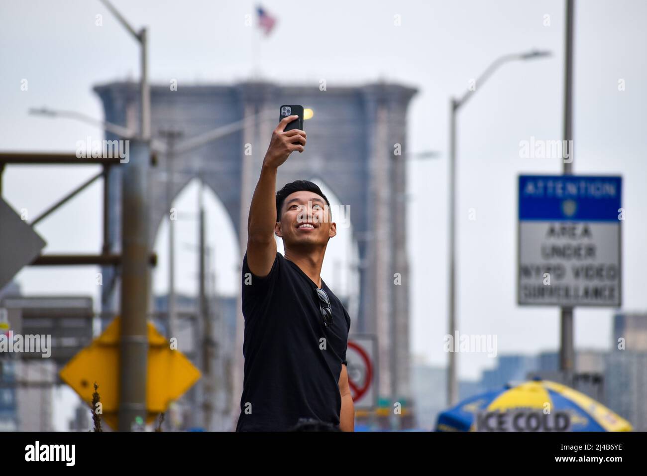 Les touristes reviennent à New York. Un touriste est vu prendre un selfie devant le pont de Brooklyn à New York le 13 avril 2022. Banque D'Images