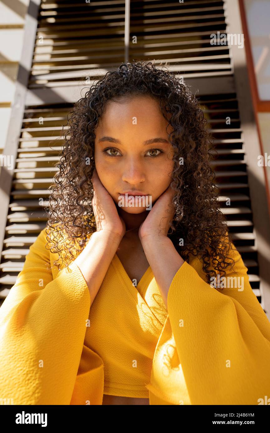 Portrait d'une jeune femme noire colorée debout devant des volets victoriens Banque D'Images