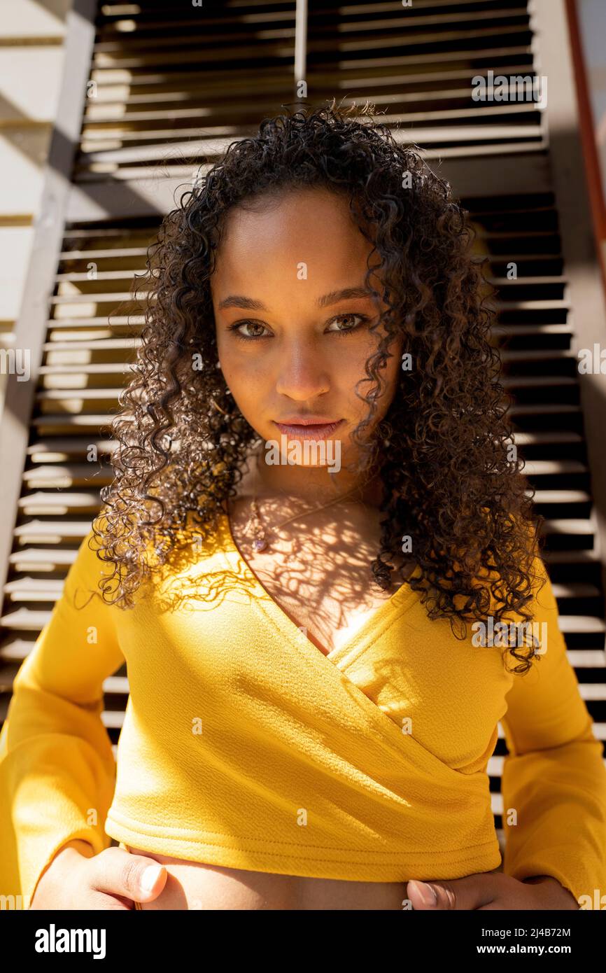 Portrait d'une jeune femme noire colorée debout devant des volets victoriens Banque D'Images