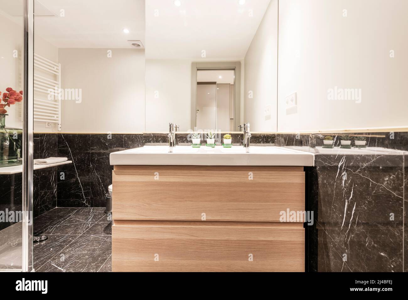 meuble lavabo en bois sous miroir mural, carrelage en marbre noir et cabine  de douche avec cloison en verre Photo Stock - Alamy