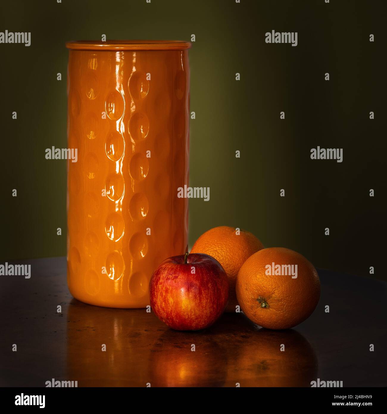 Photo sombre et atmosphérique, fiole vide pour fleurs, oranges et pommes, faite à la lumière naturelle. Banque D'Images