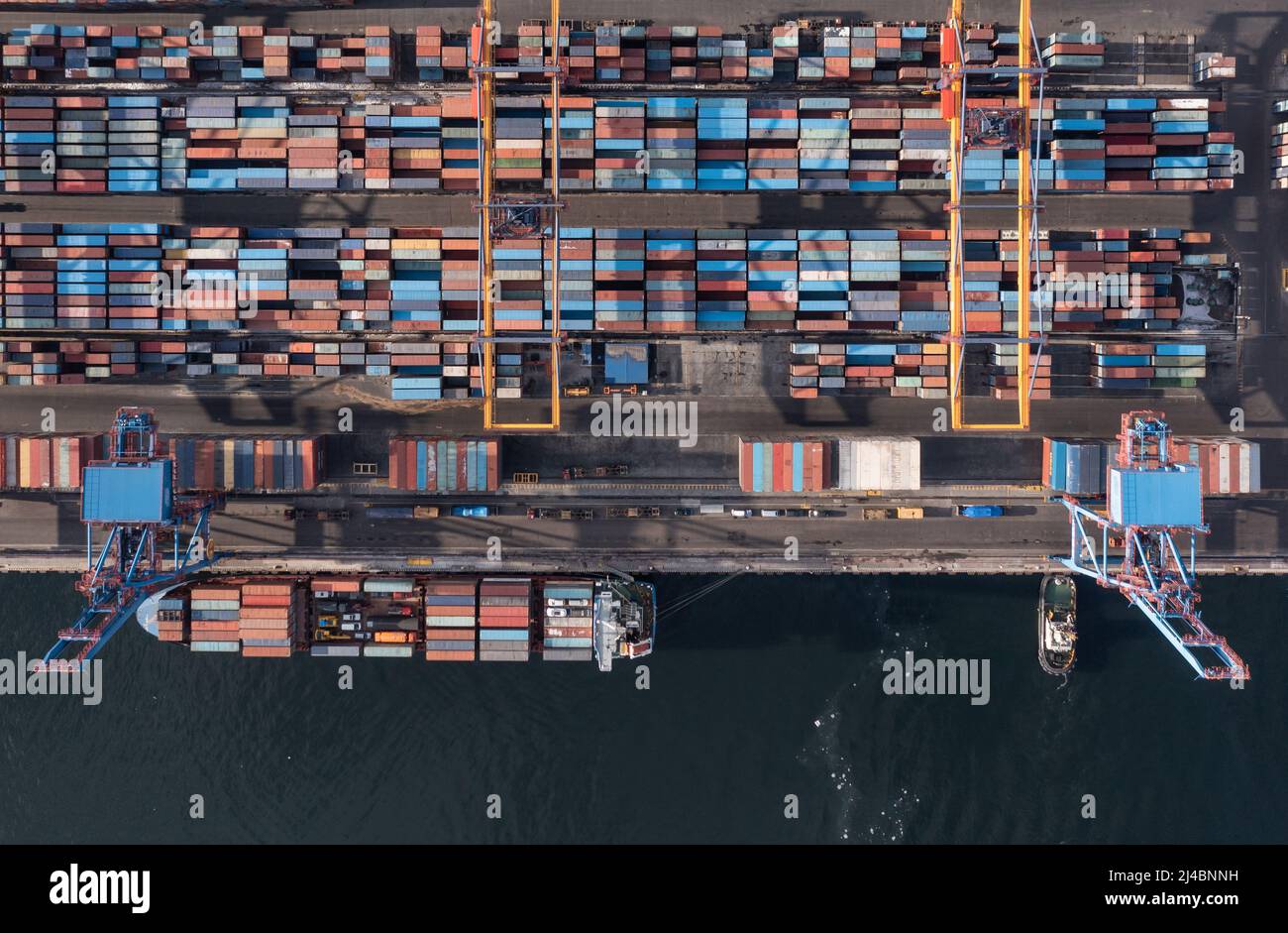 Vladivostok, Russie - 28 janvier 2022 : Vue de dessus du terminal des conteneurs du port maritime. En hiver, un bateau à conteneurs est en train de charger au quai. Banque D'Images