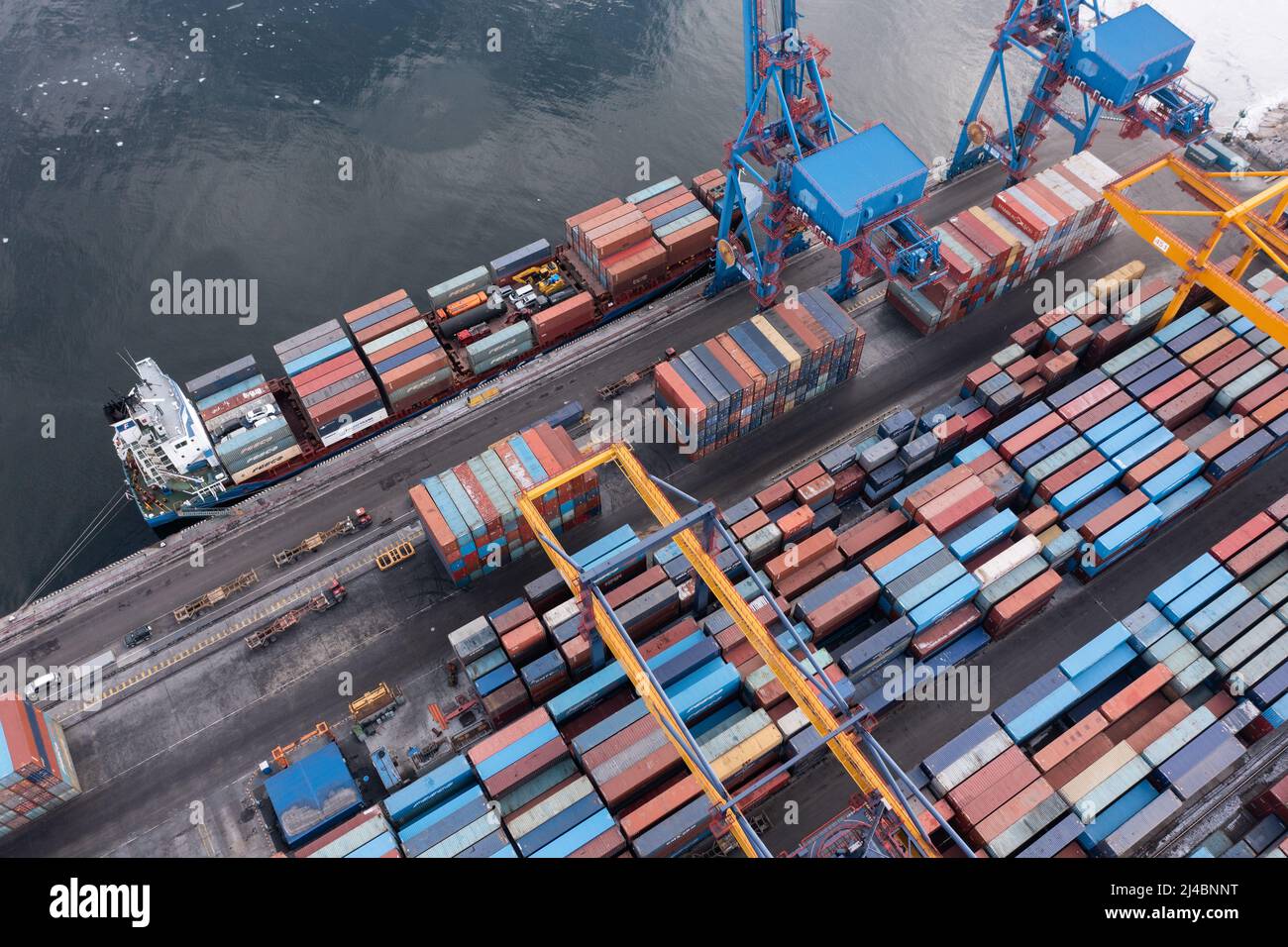 Vue de dessus du terminal de conteneurs du port maritime. En hiver, un bateau à conteneurs est en train de charger au quai. Banque D'Images