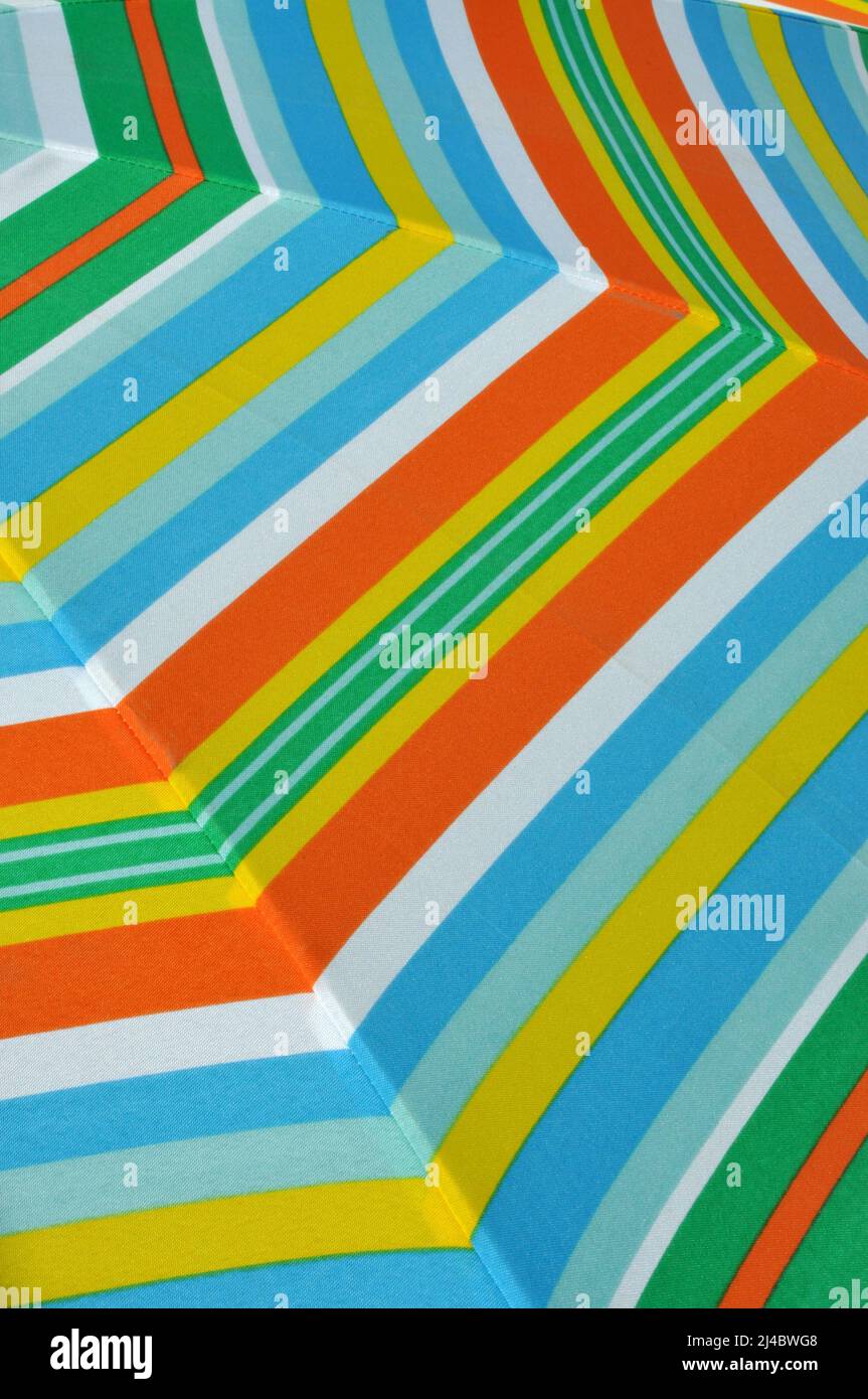 Gros plan de parasol d'été à rayures vertes, orange, bleues et blanches Banque D'Images