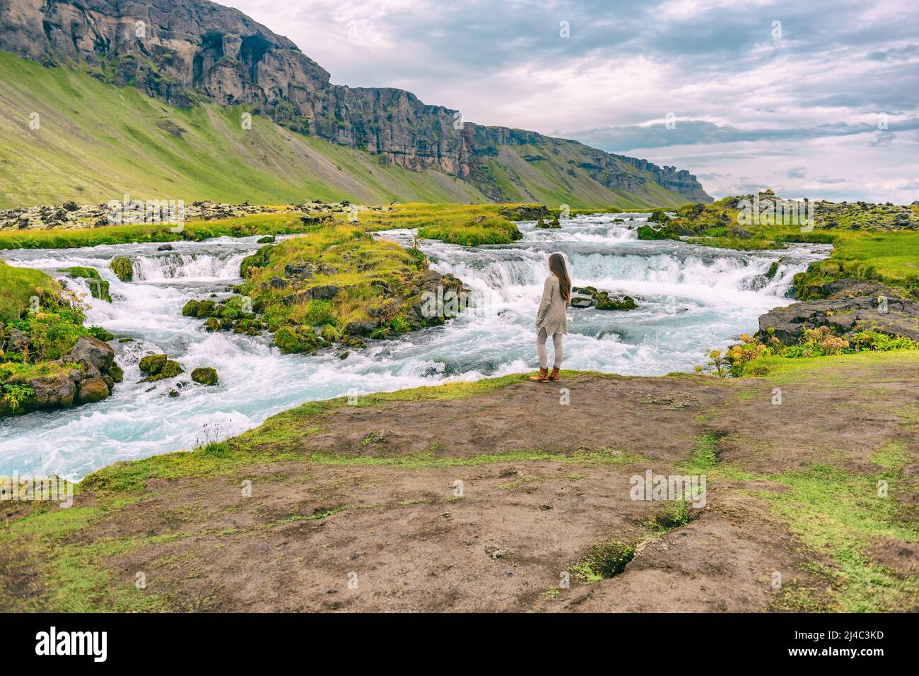 Femme marchant en cascade sur l'Islande. Fille touriste dans des vêtements décontractés visite paysage de la nature islandaise. Banque D'Images