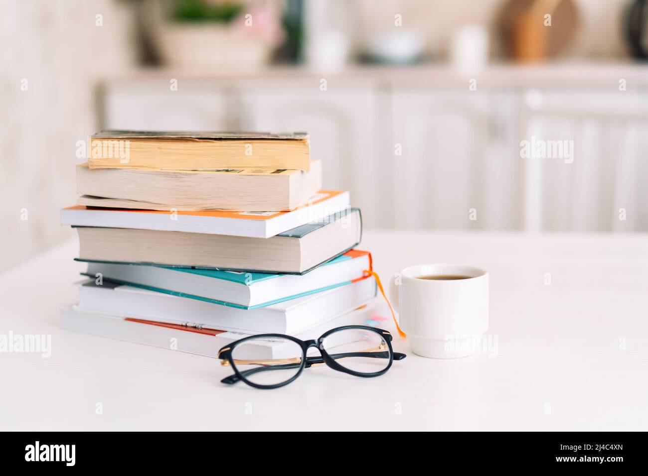 Pile de livres avec des verres et une tasse de café debout sur une table Banque D'Images
