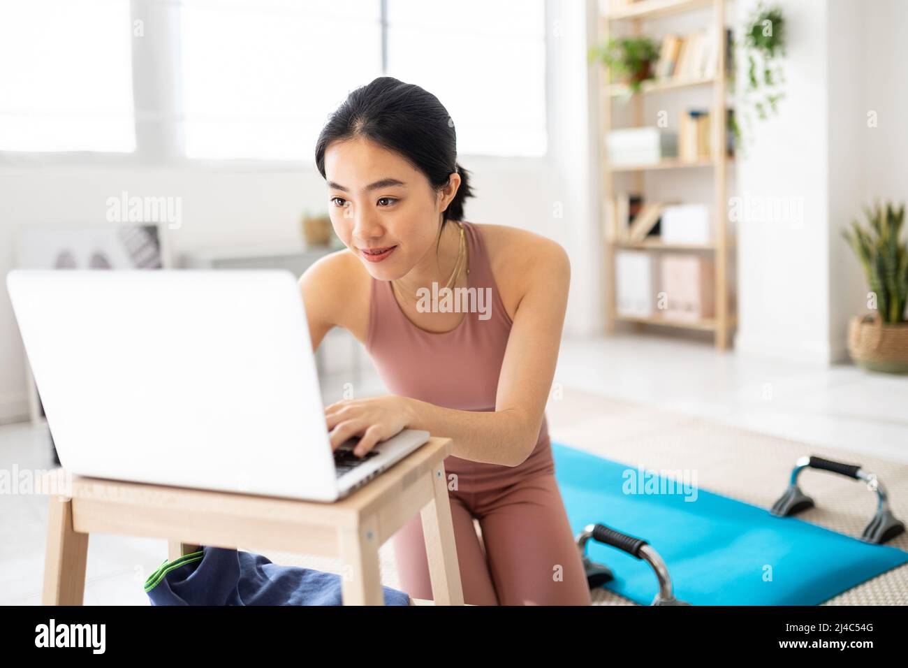 Femme de sport se connectant à un cours de fitness en ligne sur ordinateur portable Banque D'Images
