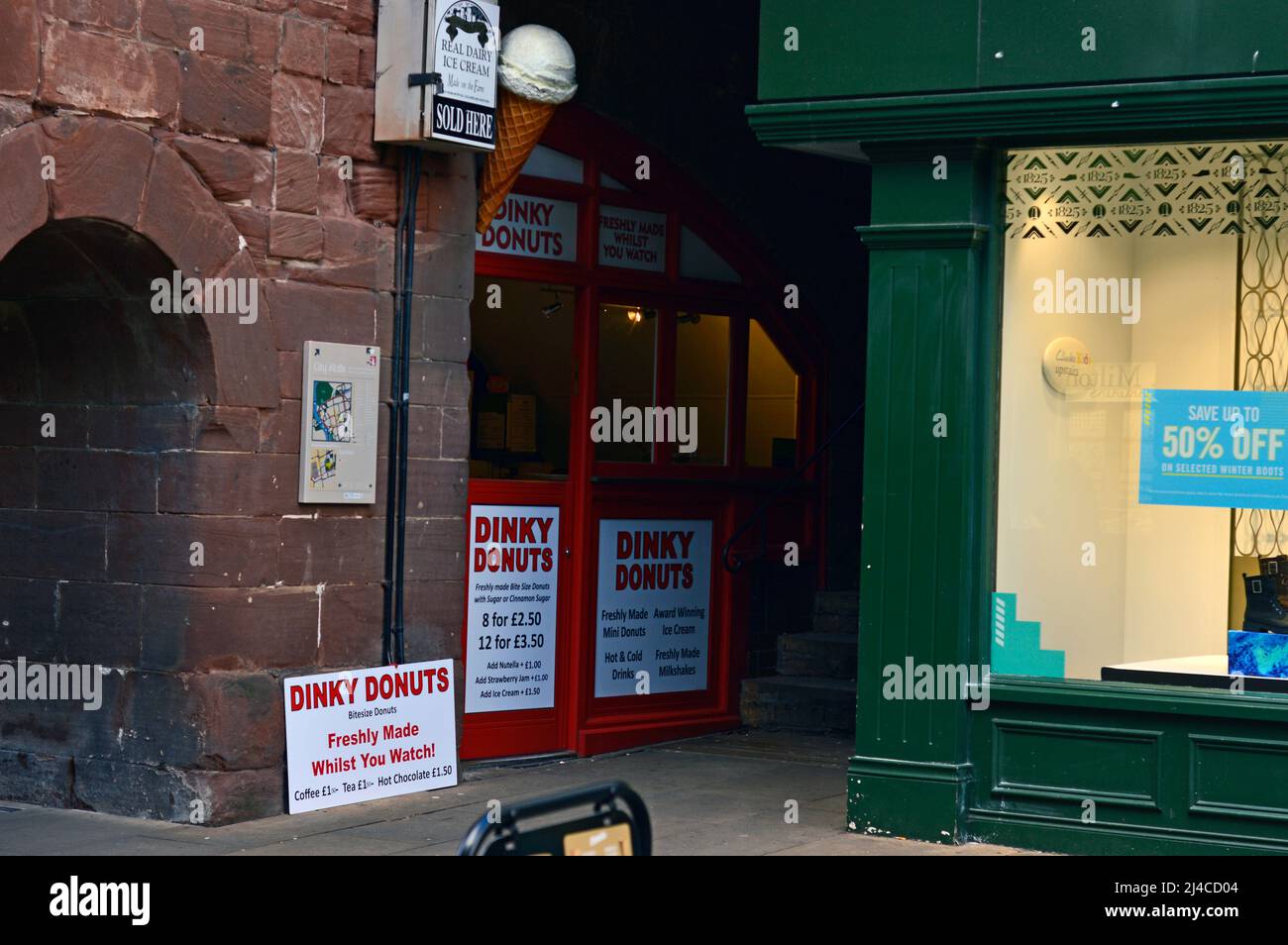 CHESTER. CHESHIRE. ANGLETERRE. 02-10-22. La sortie de restauration rapide Dinky Donuts est construite dans une arche de l'Eastgate dans les murs de la ville. Banque D'Images