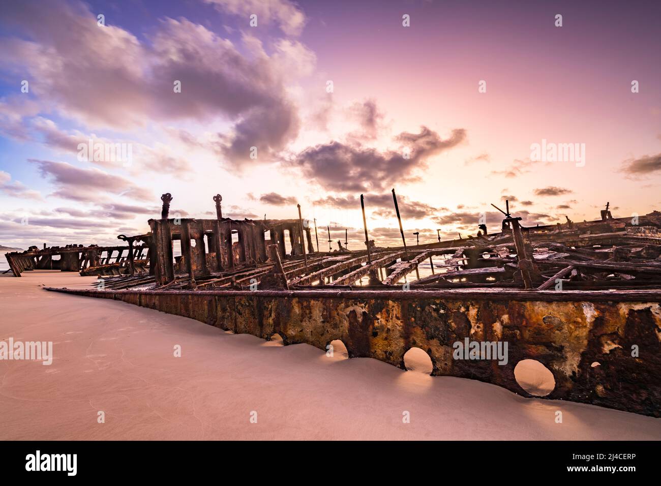 Naufrage de Maheno au lever du soleil, ses trous de port visibles juste au-dessus du sable. Soixante-dix-cinq Mile Beach, Fraser Island, Queensland, Australie Banque D'Images