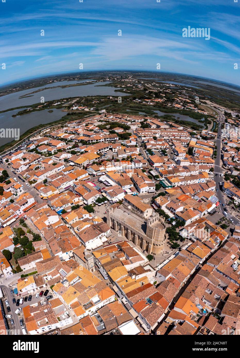 Tir de drone, photo de drone de Saintes-Maries-de-la-Mer avec la vieille ville, le port, l'église notre Dame et les champs de sel en arrière-plan, département Banque D'Images