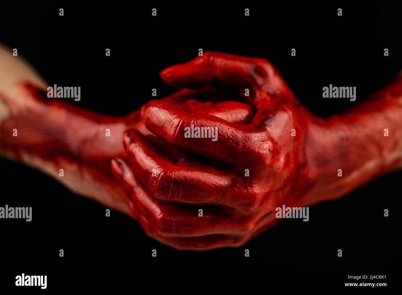 Les poings des femmes dans le sang sur fond noir. Poing et paume. Banque D'Images