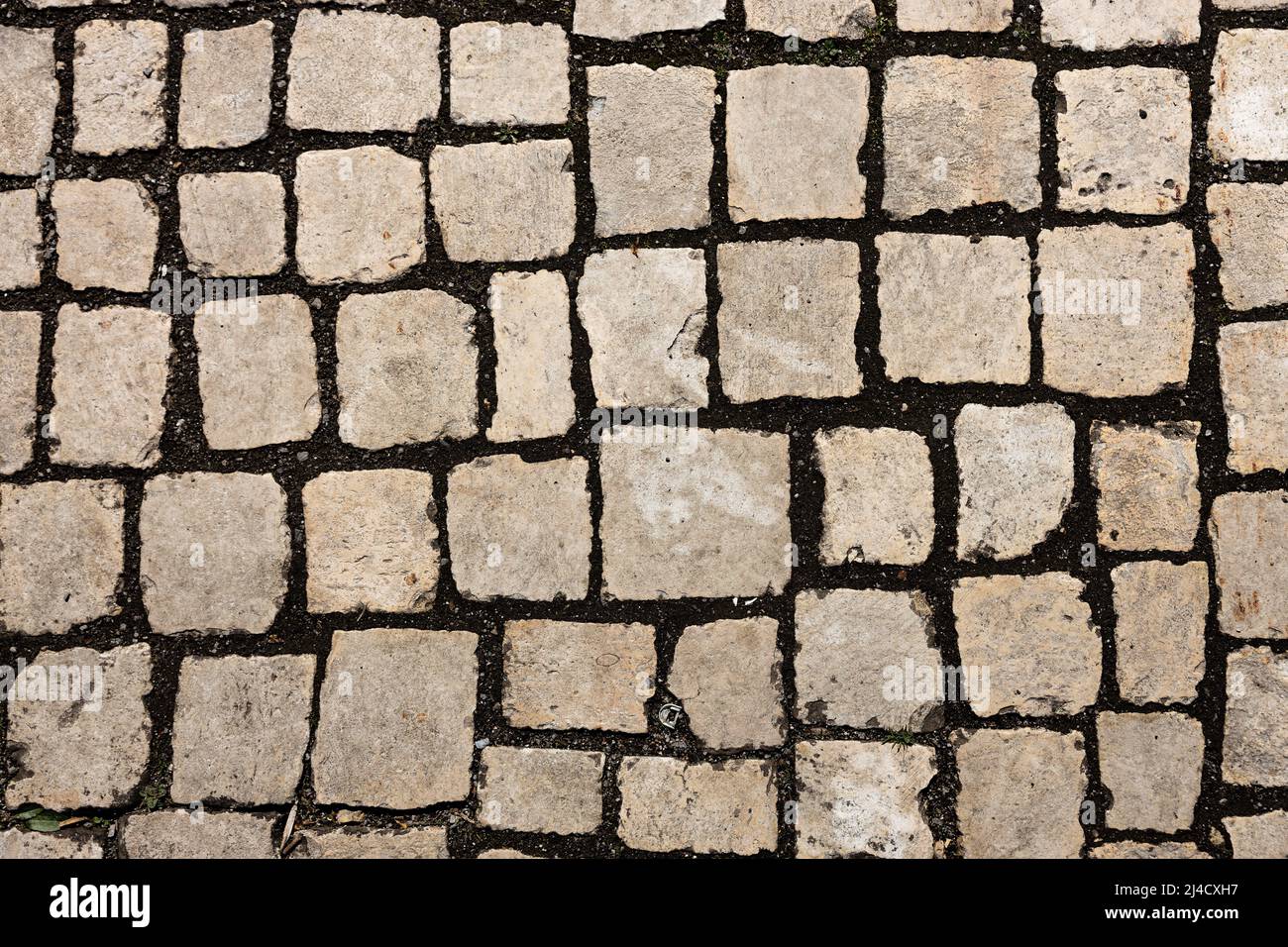 Mosaïque de petits cubes de marbre. Trottoirs et carrés formés de tapis de pierre avec carrés. Vieux pavés. Photo de haute qualité Banque D'Images