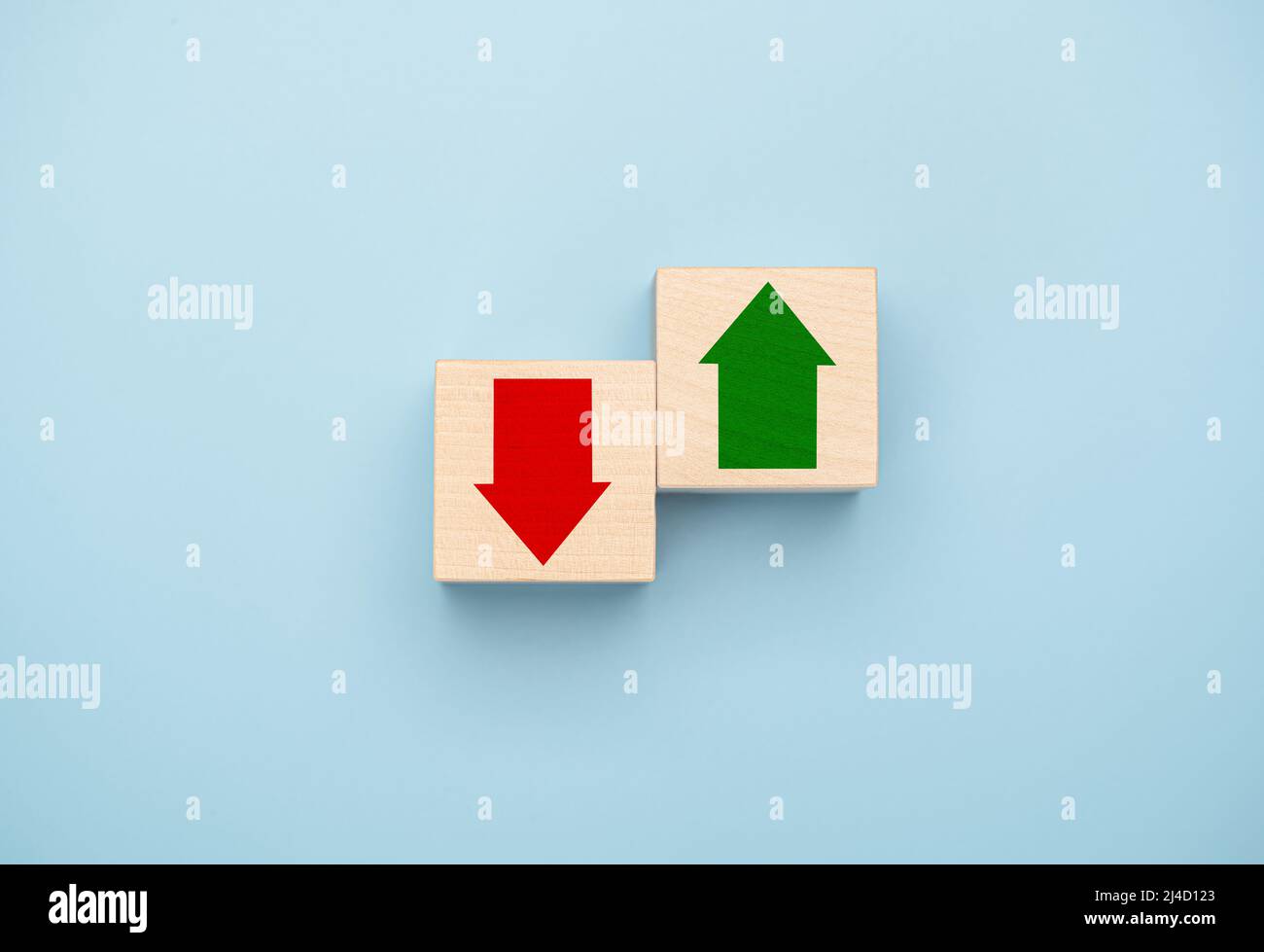 Tendances montantes et descendantes. Flèche verte vers le haut sur le côté lumineux et flèche rouge vers le bas sur le côté sombre qui impriment l'écran sur un cube en bois pour l'économie et le busi Banque D'Images