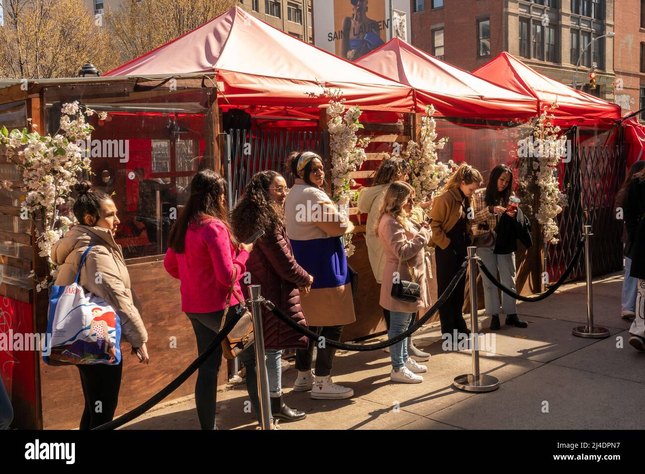 Dessiné par les médias sociaux et le bouche à oreille des centaines de personnes attendent en ligne pour entrer dans la maison de ville de Kate Spade, une activation immersive de marque à Soho à New York, le samedi 2 avril 2022. Les visiteurs ont été traités à une copie du livre de table de café des marques "fêtez cela! Occasions », un bouquet et un certain nombre de moments ininflammables. (© Richard B. Levine) Banque D'Images