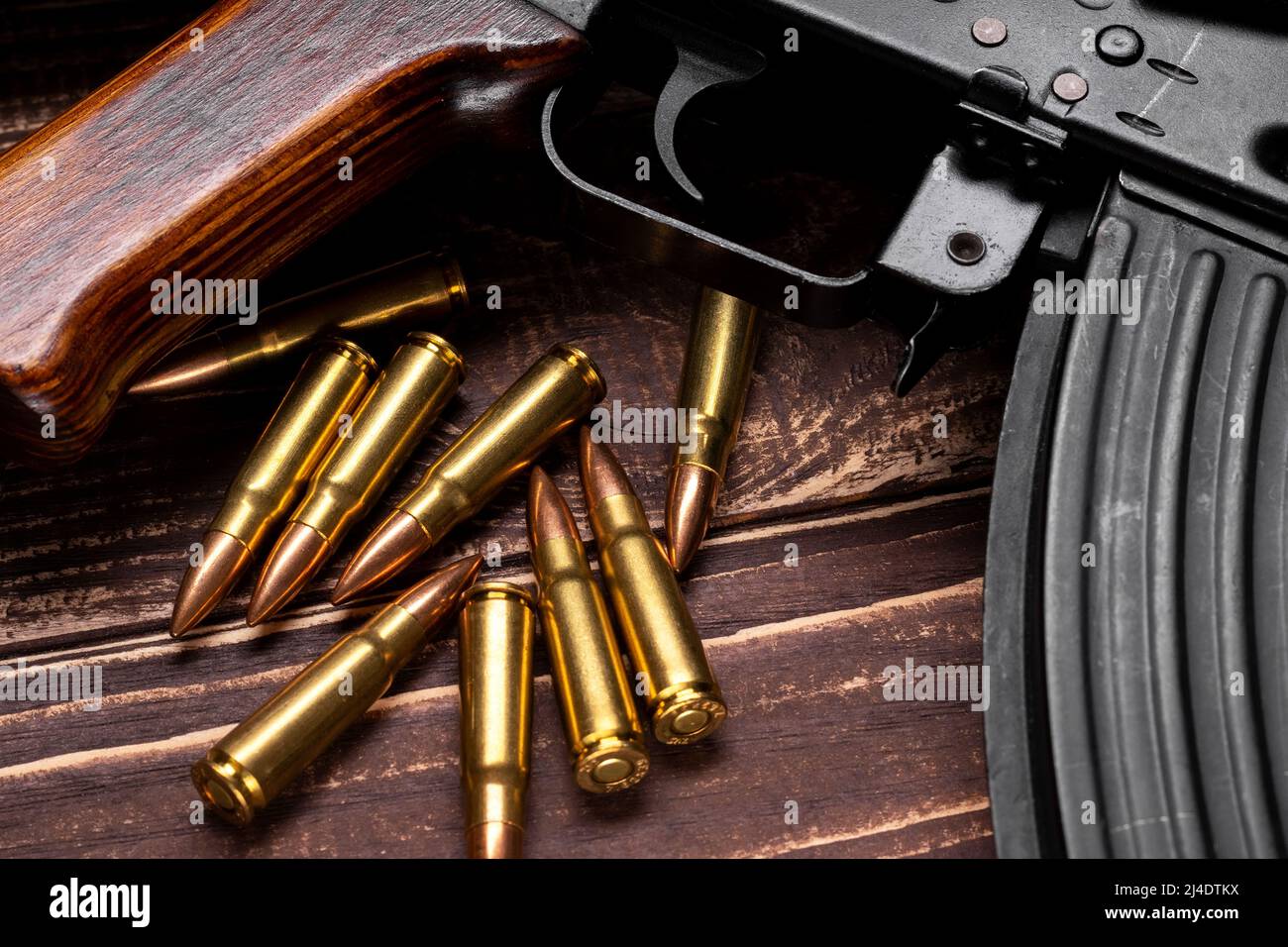 Balles et fusil d'assaut Kalashnikov sur fond de bois. Cartouches calibre 7,62 pour ak 47 gros plan. Mise au point sélective Banque D'Images