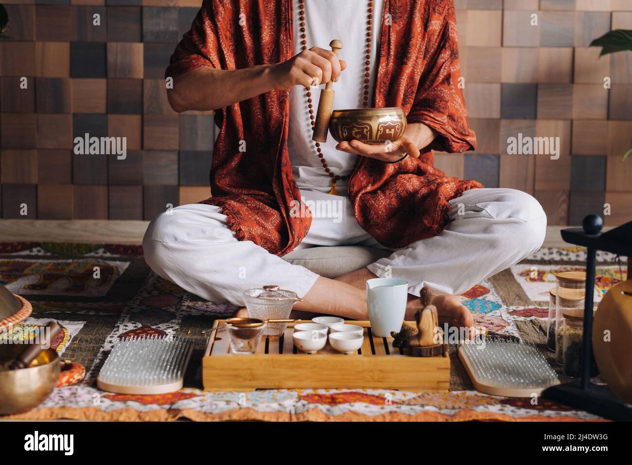 Bol de chant tibétain entre les mains d'un homme lors d'une cérémonie du thé Banque D'Images