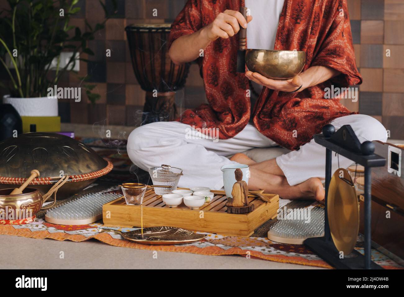 Bol de chant tibétain entre les mains d'un homme lors d'une cérémonie du thé Banque D'Images