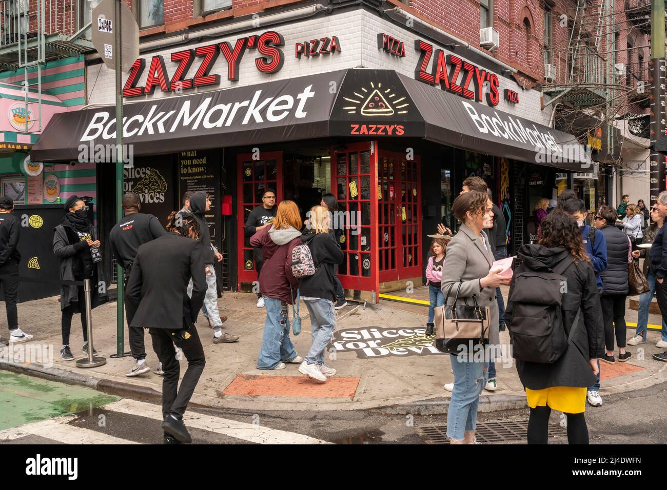 Les gens affluent à ZazzyÕs Pizza dans le quartier du Lower East Side de New York pour participer à la promotion BackmarketÕs ÒSlices for DevicesÓ le samedi 9 avril 2022. Backmarket, un revendeur de technologies d'occasion, achète des téléphones intelligents éligibles d'occasion en donnant de l'argent sur place. Les propriétaires de téléphones non admissibles peuvent les échanger contre des tranches de pizza et d'autres friandises. (© Richard B. Levine) Banque D'Images