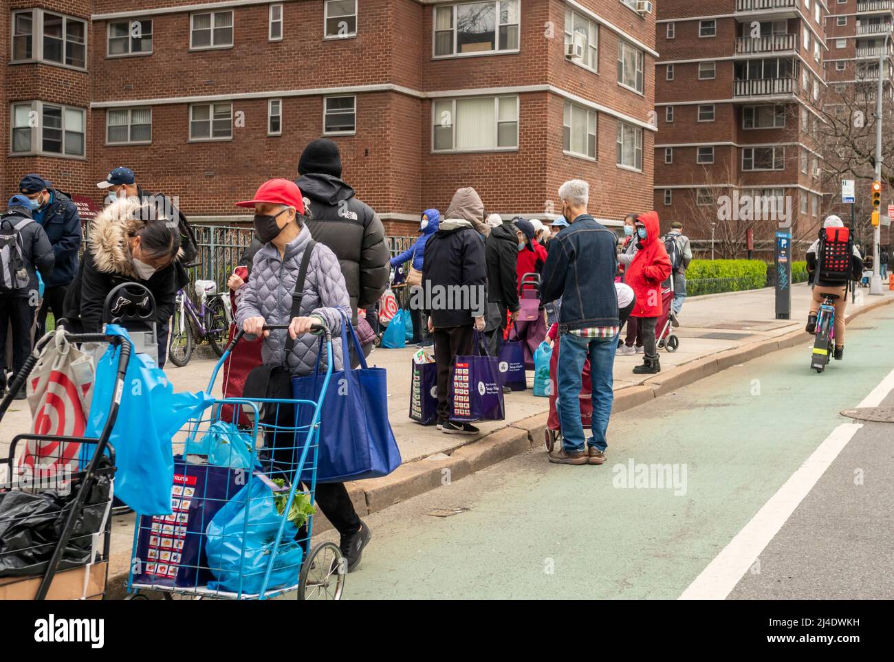 Des gens avec leurs largesses à l'extérieur de la pantry alimentaire des Saints Apôtres à Chelsea, à New York, le mardi 5 avril 2022. .(© Richard B. Levine) Banque D'Images