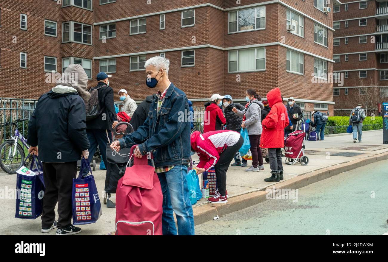 Des gens avec leurs largesses à l'extérieur de la pantry alimentaire des Saints Apôtres à Chelsea, à New York, le mardi 5 avril 2022. .(© Richard B. Levine) Banque D'Images