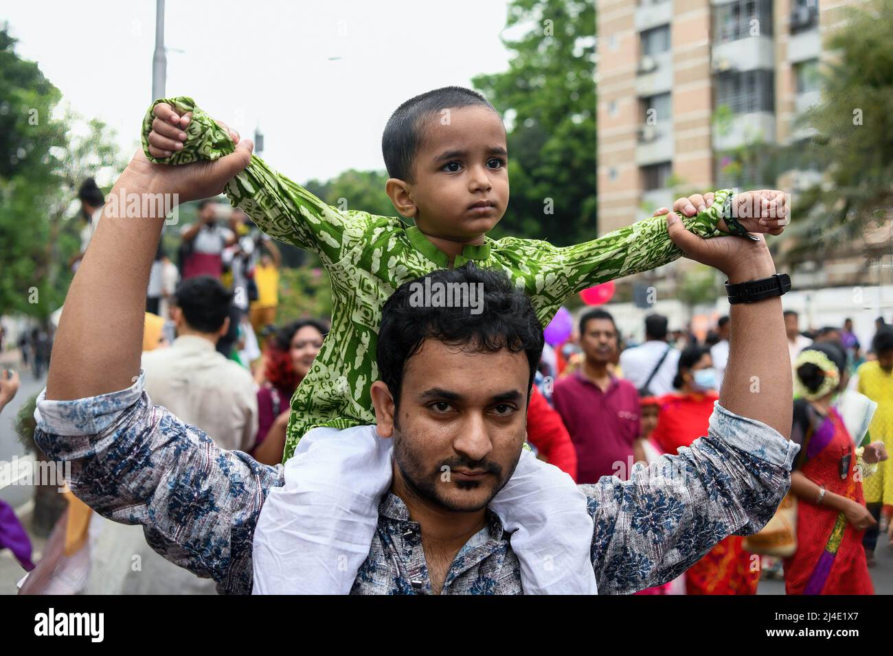 Un père porte son fils sur les épaules lors de la célébration du premier jour du nouvel an bengali. Le peuple bangladais participe à une parade colorée pour célébrer le premier jour du nouvel an bengali ou de Pohela Boishakh le 14 avril. Des milliers de bangladais le célèbrent avec différents rassemblements colorés, des programmes culturels avec de la danse et de la musique traditionnelles, cette année bengali a été introduite sous le régime de l'empereur Akbar pour faciliter la collecte des revenus au 16th siècle. (Photo de Piyas Biswas/SOPA Images/Sipa USA) Banque D'Images