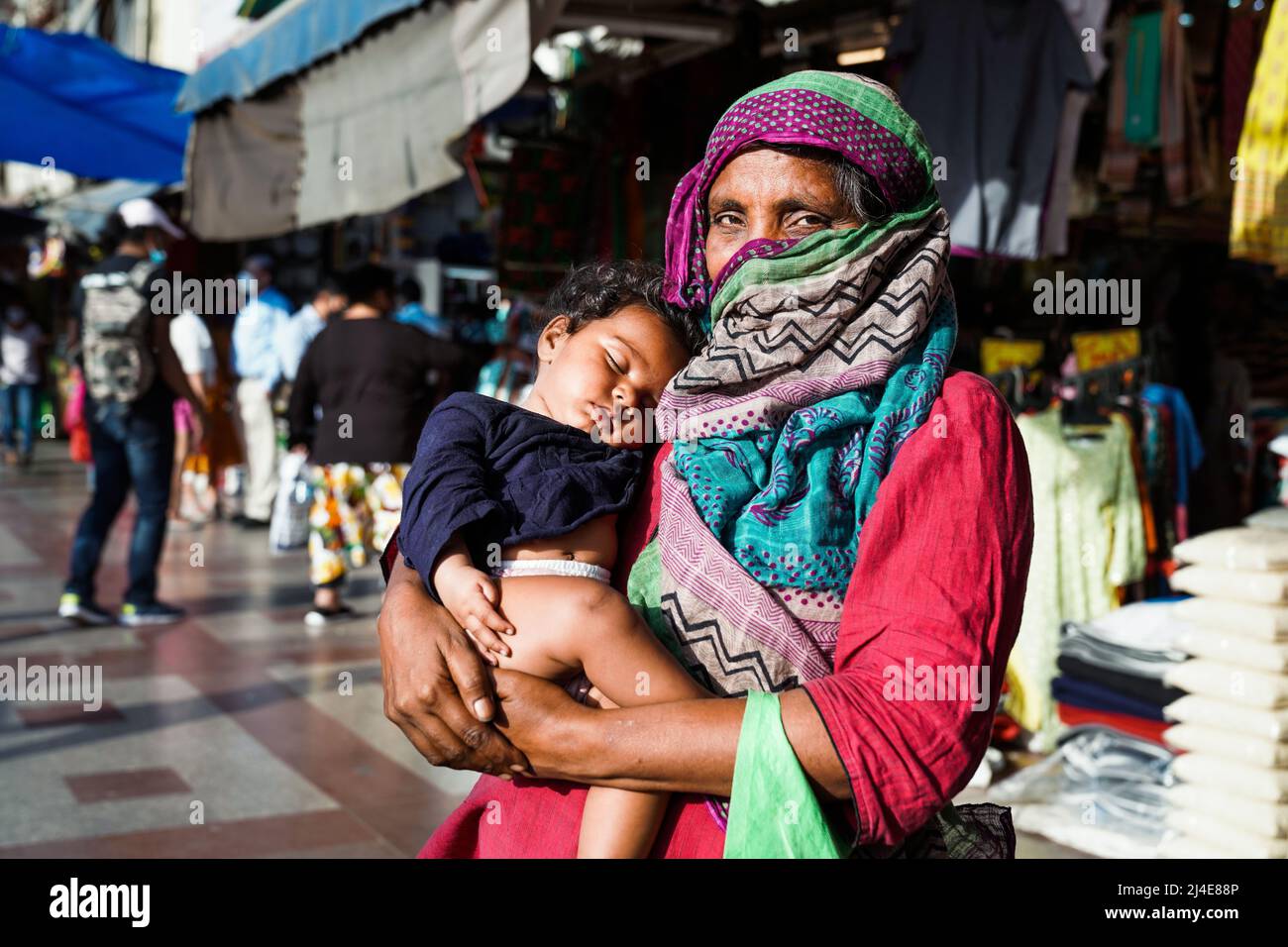 La vieille femme mendière indienne avec son bébé engendra les aumône dans la rue de New Delhi, en Inde Banque D'Images