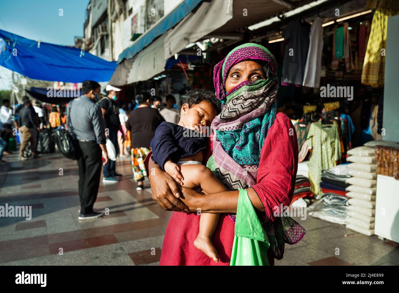 La vieille femme mendière indienne avec son bébé engendra les aumône dans la rue de New Delhi, en Inde Banque D'Images