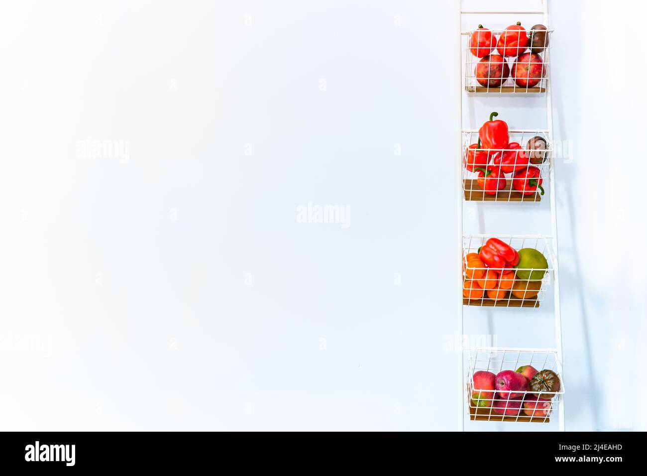 Portoir vertical blanc avec étagères pleines de légumes et de fruits, espace de texte Banque D'Images