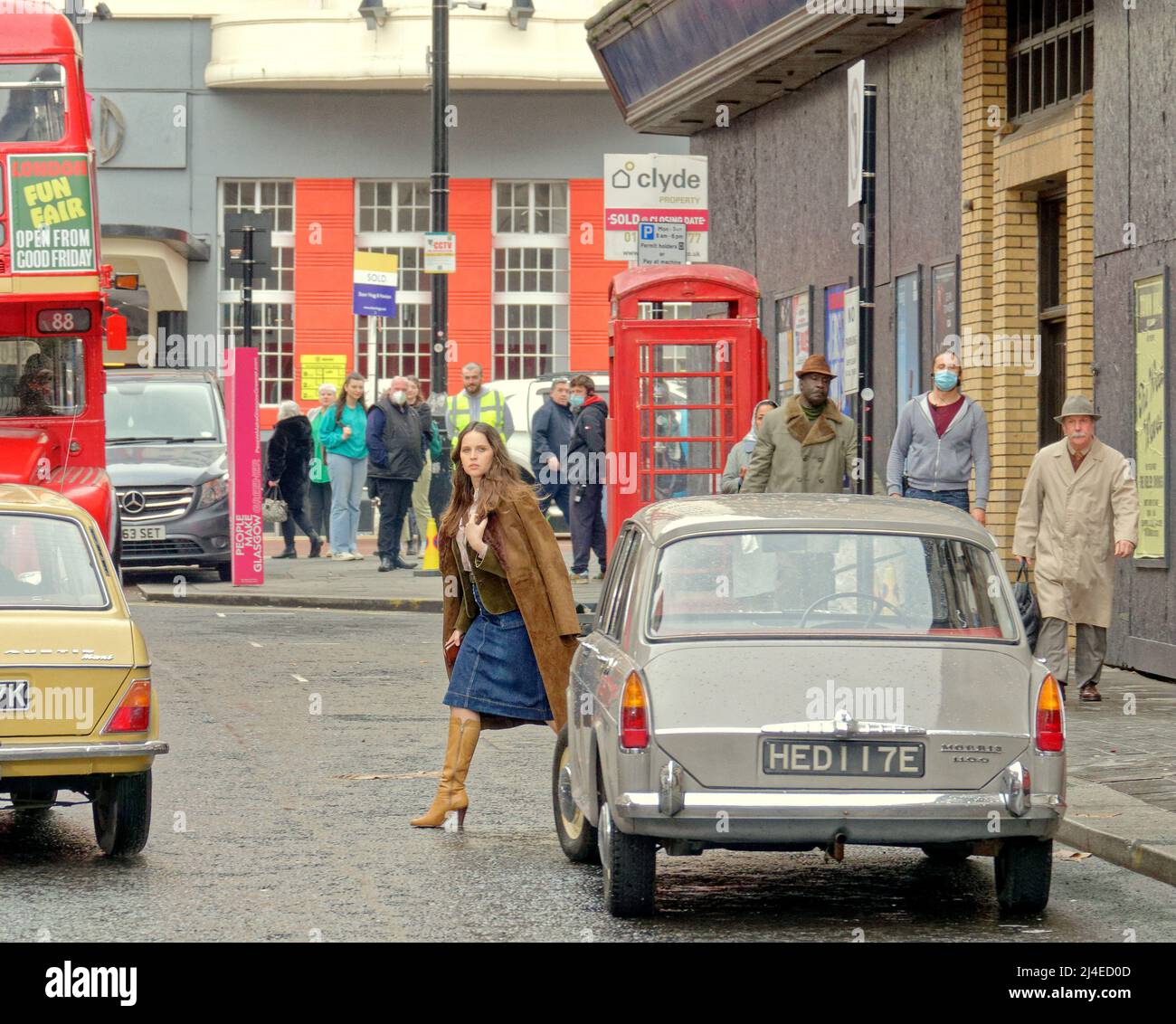 Glasgow, Écosse, Royaume-Uni 14th avril, 2022 Hollywood vient à nouveau à la ville à l'air d'avoir vu Miss jones comme Felicity Jones tournage dans la ville a vu un ensemble très clairsemée d'yeux, comme elle regardait chaque pouce une star de cinéma parmi le drab des années soixante-dix Londres ensemble qui est Glasgow. Elle est vue en quittant le célèbre pub de glasgow le griffin et en se dirigeant vers et en téléphonant d'une boîte de téléphone rouge. Crédit Gerard Ferry/Alay Live News Banque D'Images