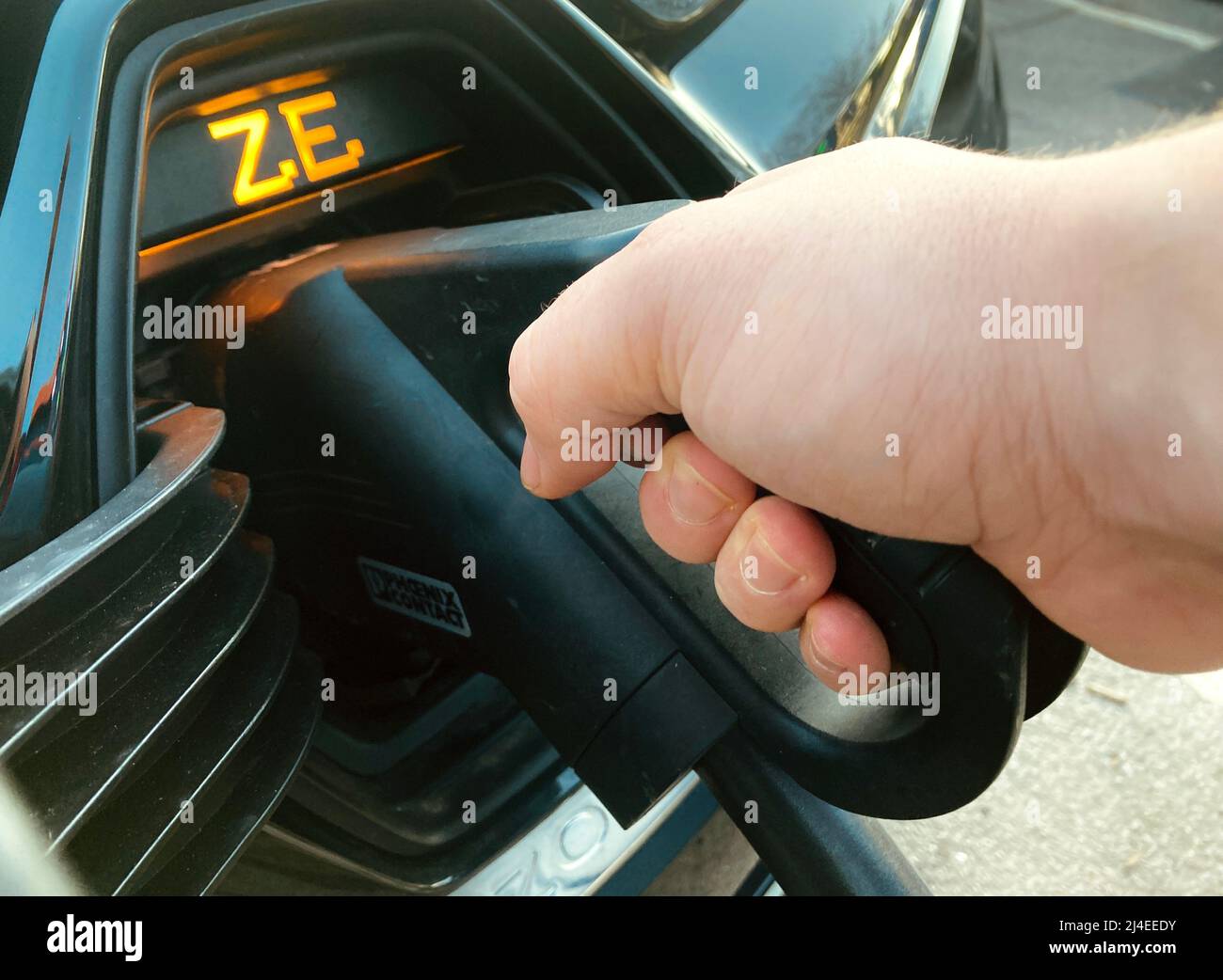 Une voiture électrique Renault Zoe chargée avec la fiche de chargeur rapide  EV insérée dans la prise de la voiture pour la charge par la main d'une  personne Photo Stock - Alamy