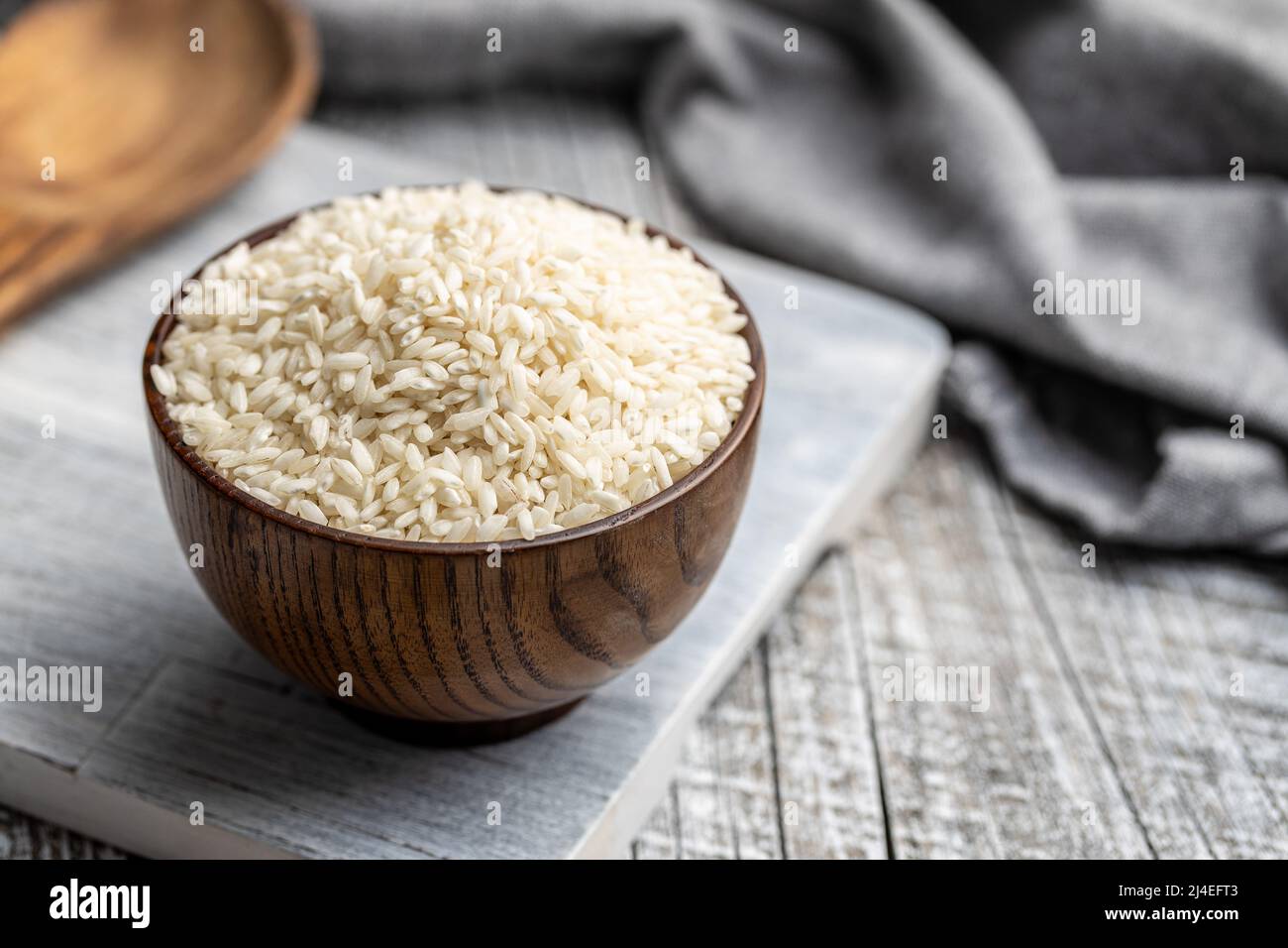 Riz risotto carnaroli non cuit dans un bol sur une table en bois. Banque D'Images