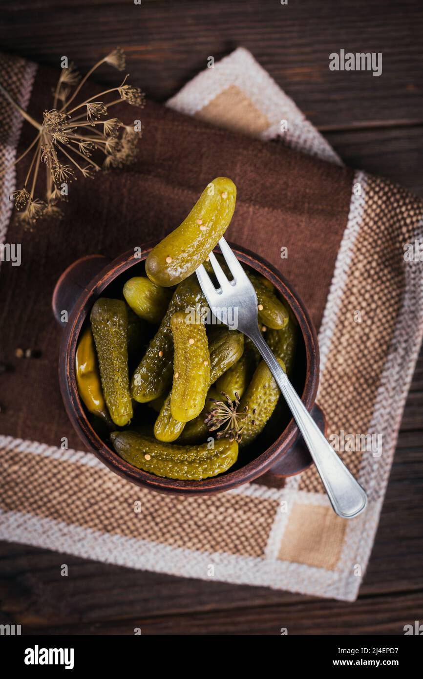 Cornichons, concombre mariné sur une fourchette, bol de légumes marinés Banque D'Images