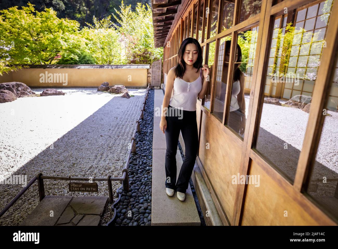 Jeune femme chinoise debout à côté d'un jardin de rock japonais Banque D'Images