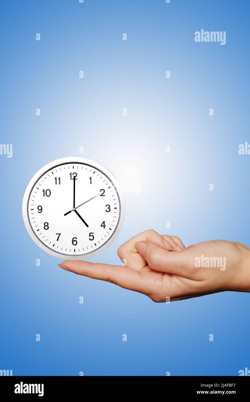 femme doigt tenant une horloge, concept de temps Banque D'Images