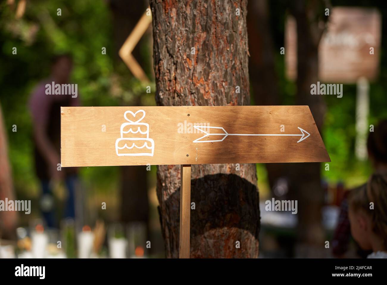 Décoration en bois gâteau de mariage signe flèche dans la forêt de pins. Banderole à gâteau sur le lieu de l'événement dans les bois à l'extérieur. Banque D'Images