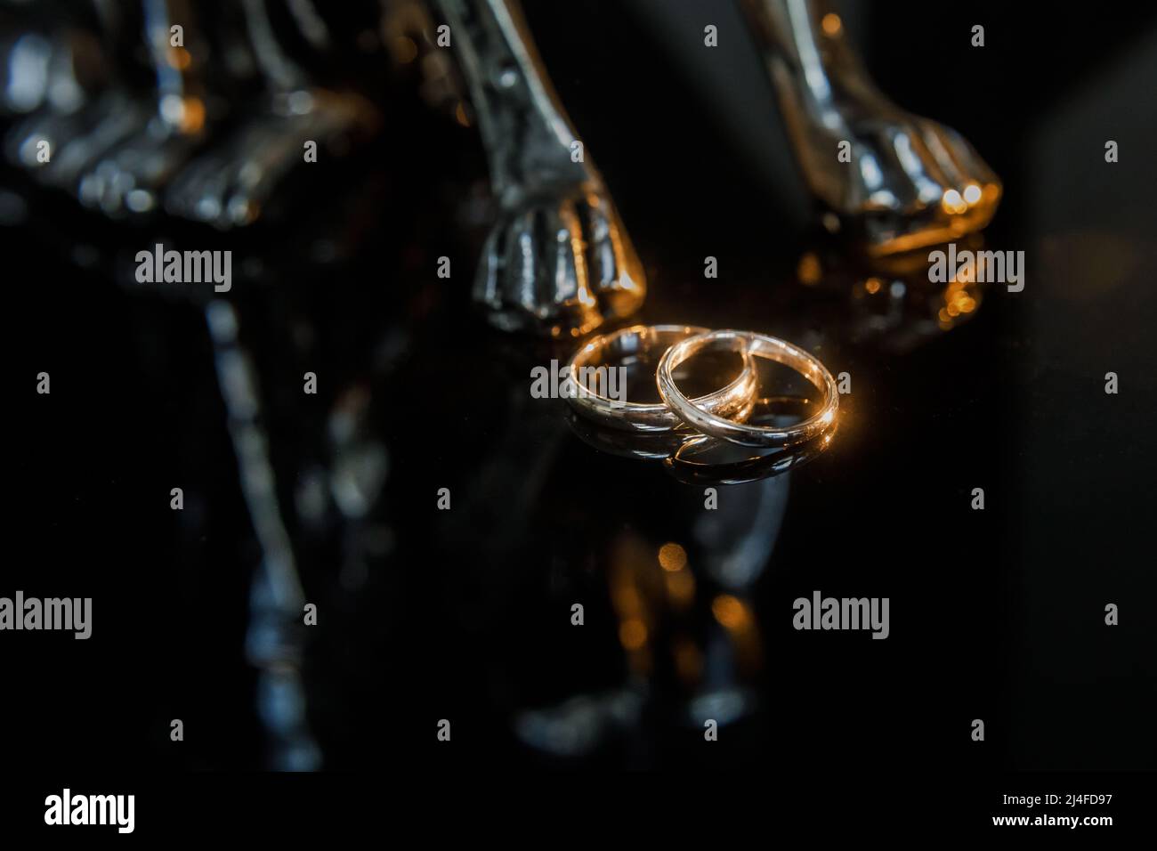 Deux anneaux de mariage dorés isolés sur le sombre, mariage anneaux concept d'arrière-plan Banque D'Images