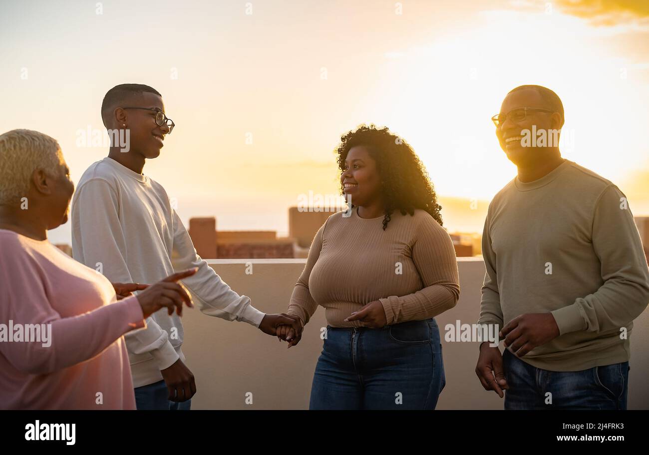 Bonne famille africaine s'amuser sur le toit pendant le coucher du soleil Banque D'Images