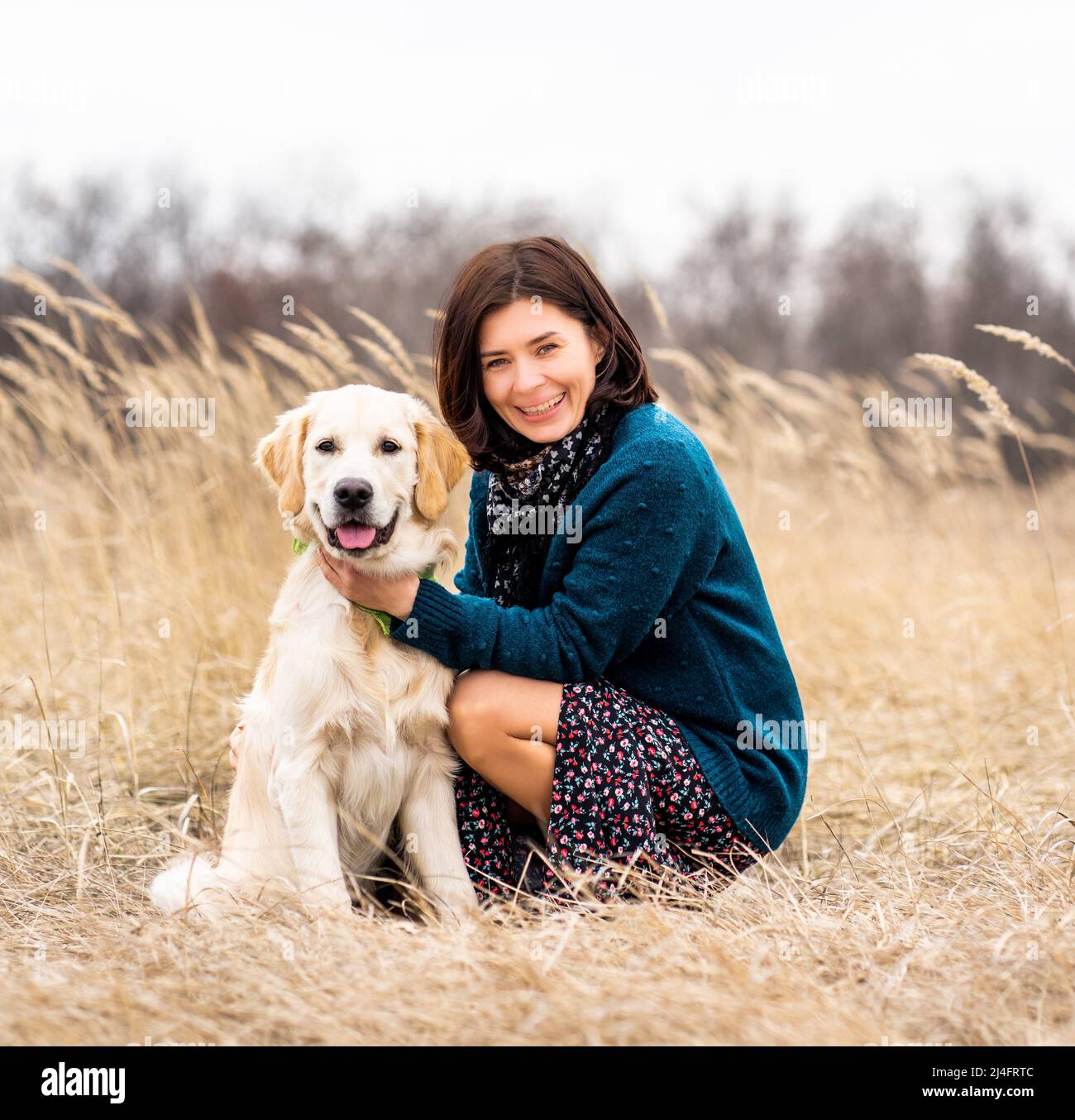 Femme joyeuse avec chien dévoué au début du printemps nature Banque D'Images