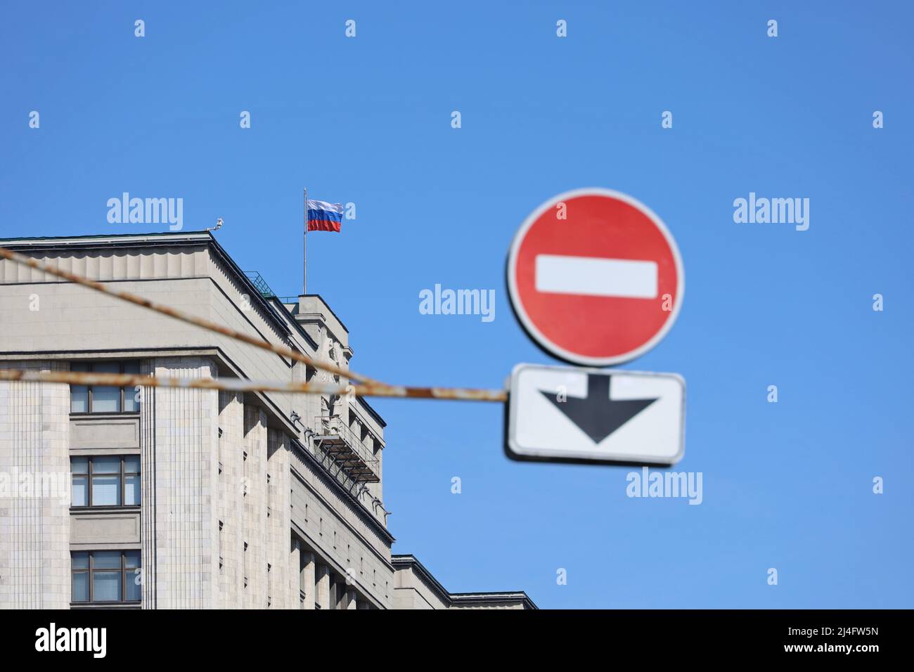 Douma d'Etat de Russie avec drapeau russe et panneau stop au premier plan contre le ciel bleu. Concept de sanctions économiques Banque D'Images