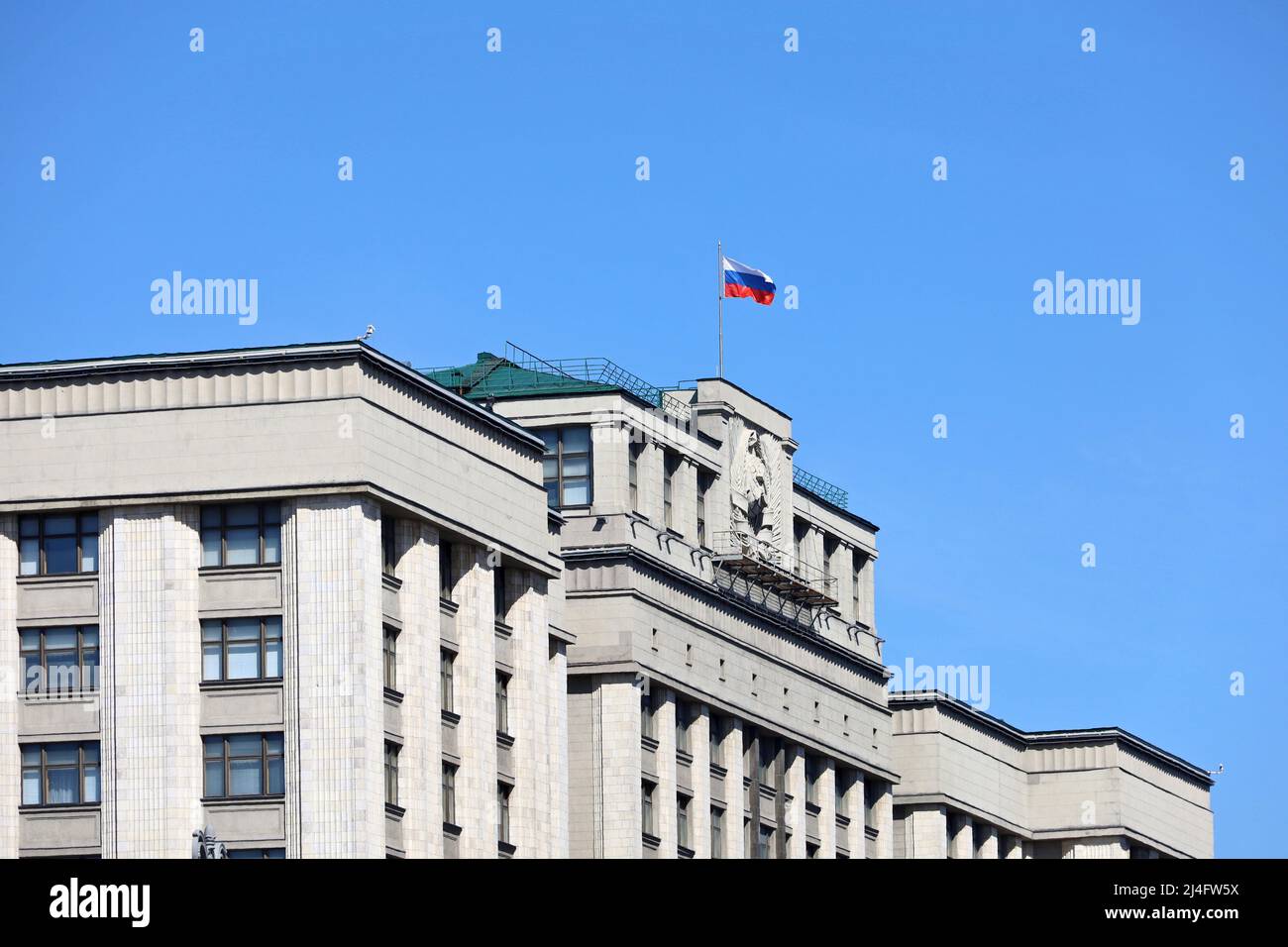 Bâtiment du Parlement à Moscou avec drapeau russe sur fond de ciel bleu clair. Façade de la Douma d'Etat de Russie Banque D'Images