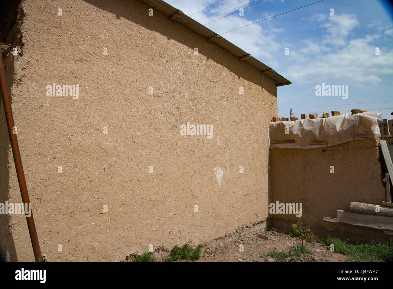 Maison asiatique traditionnelle dans un village construit à partir de briques adobe. Briques en argile et paille. Banque D'Images