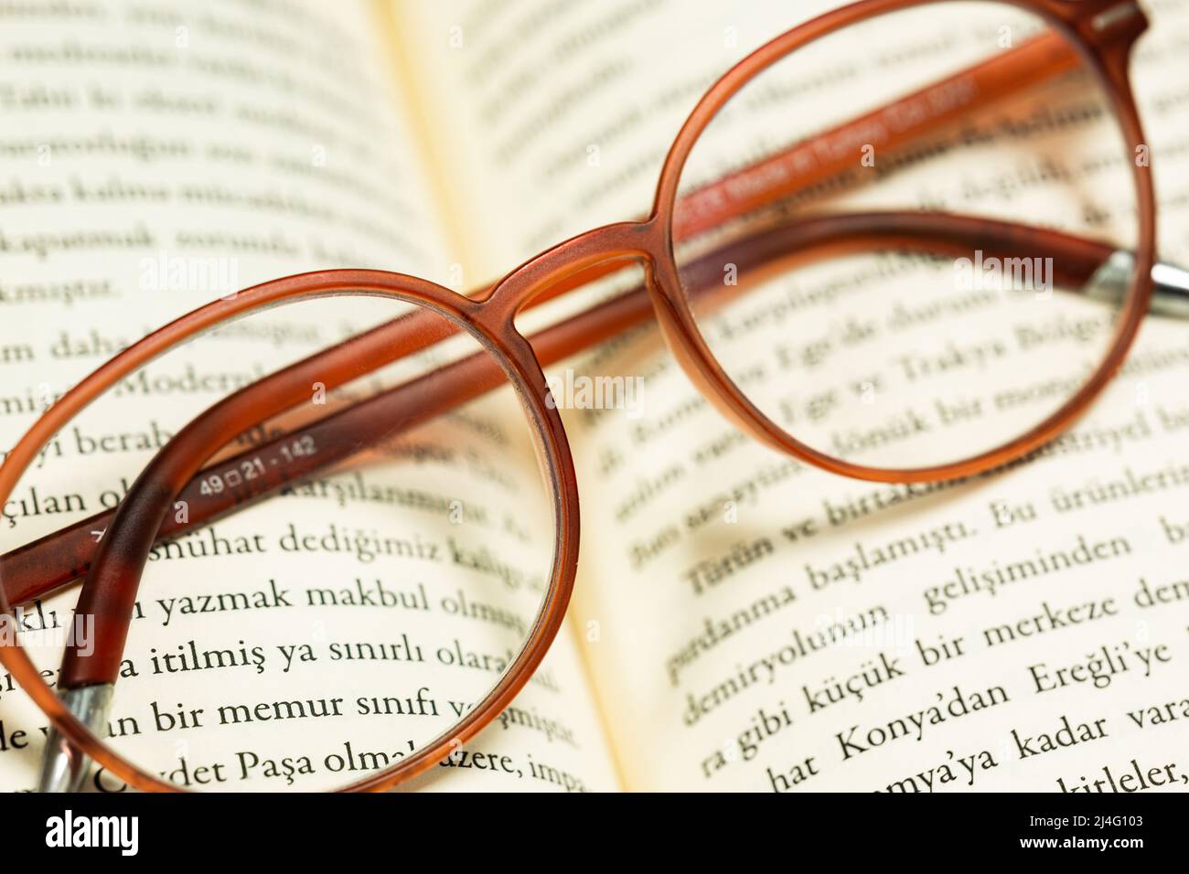 Photo d'arrière-plan vintage de verres bruns repliés sur les pages ouvertes d'un livre turc. Éducation, apprentissage, connaissance, concept de repos. Banque D'Images