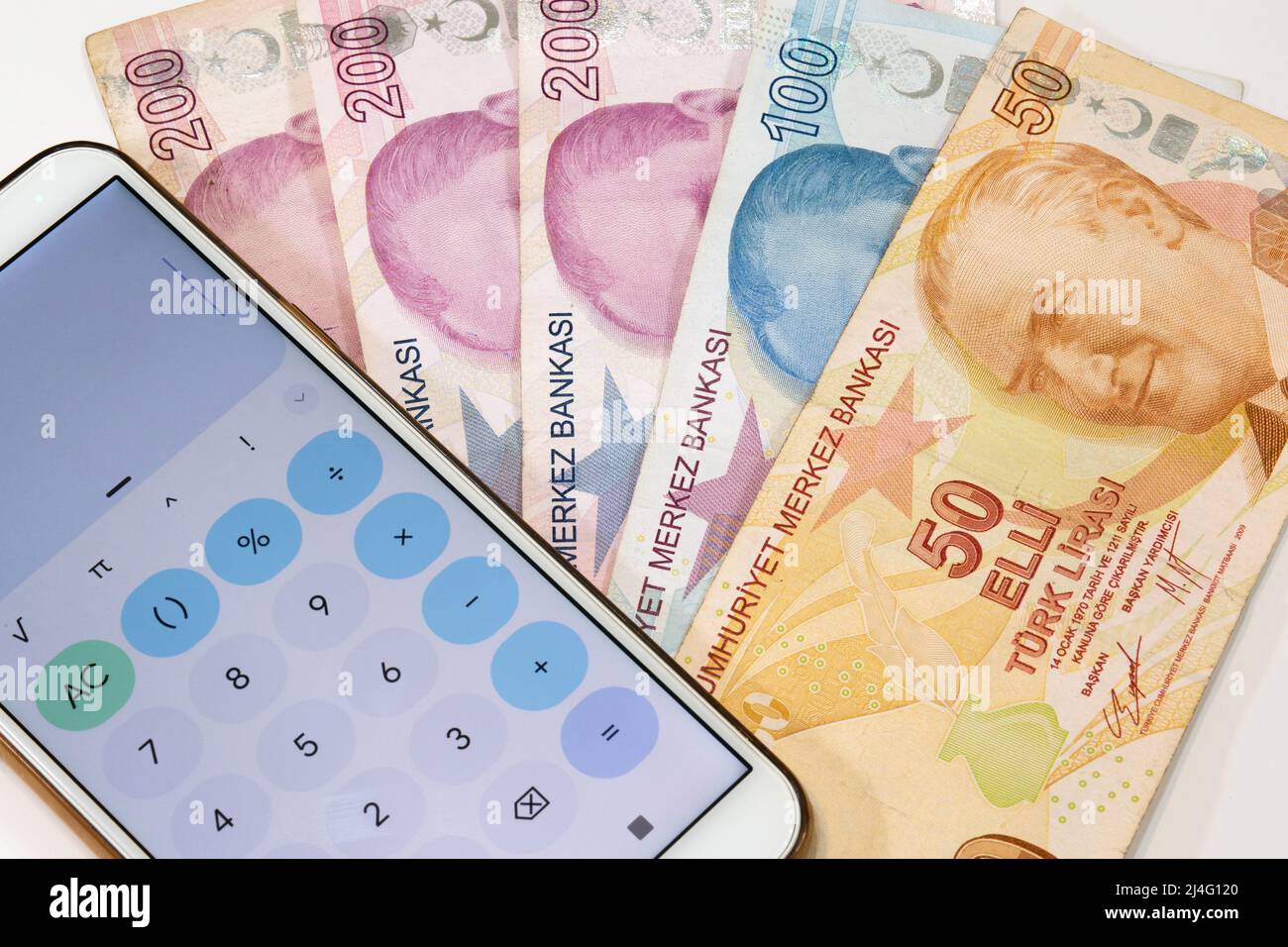 50, 100 et 200 livres de la lire turque et application de calculatrice téléphone mobile ouvert sur fond isolé. 50 billet de livre turc en priorité. Banque D'Images