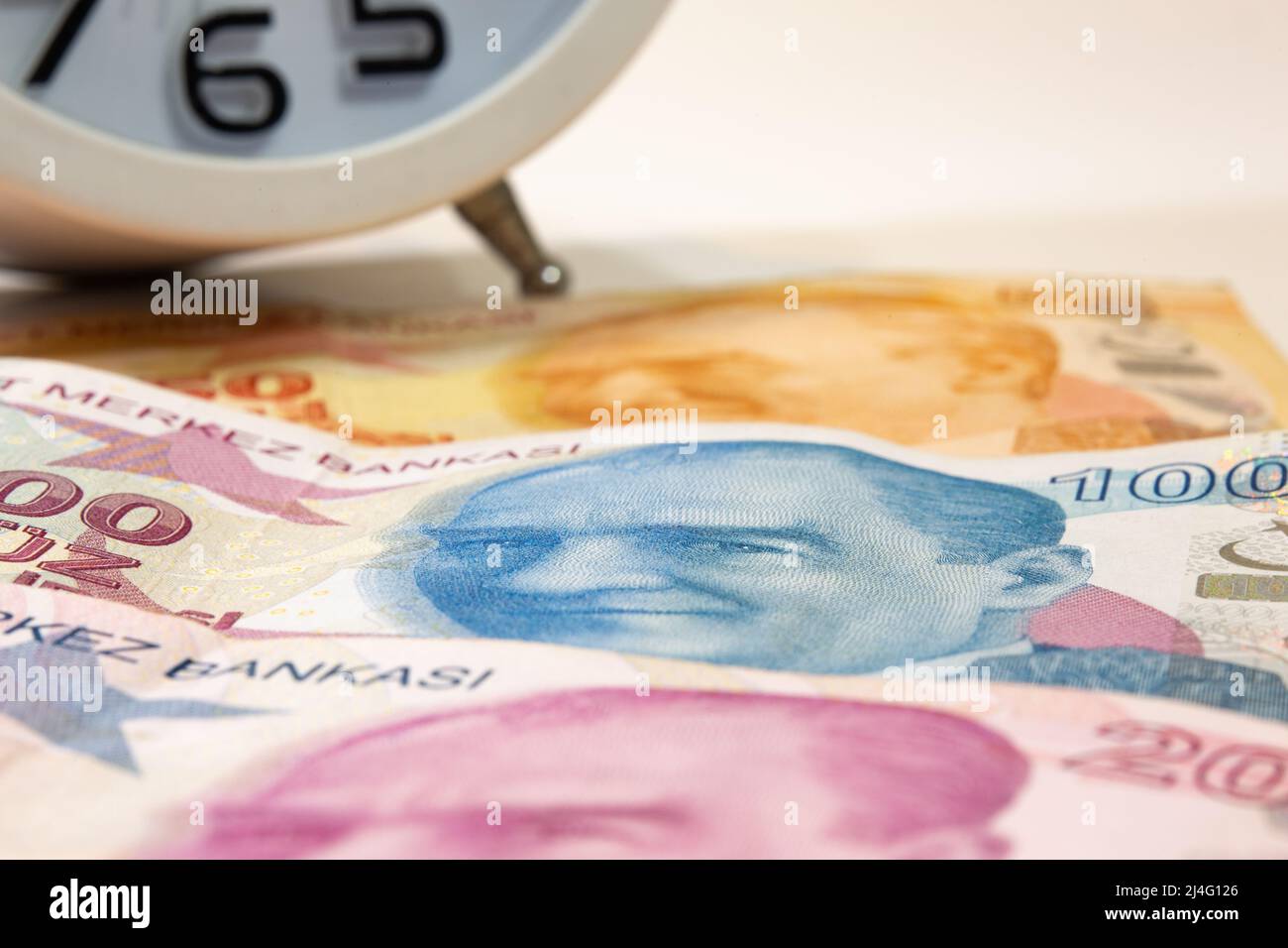 50, 100 et 200 billets turcs et réveil sur fond isolé. Image d'Atatürk sur le billet de 100 lire turque au foyer sélectif. Le temps, c'est de l'argent Banque D'Images