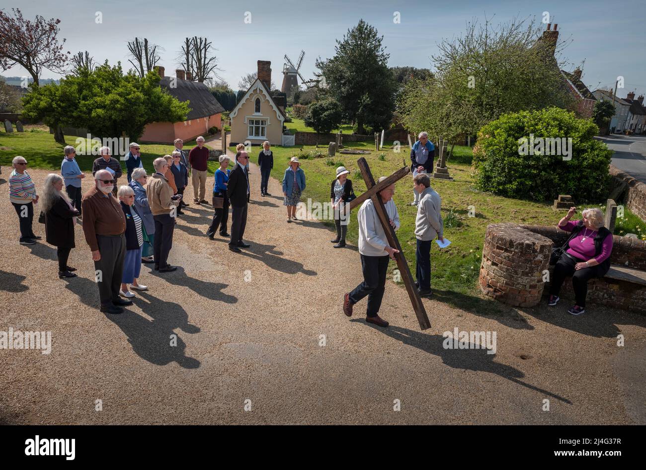 Thaxted, Essex, Royaume-Uni. 15th avril 2022. Vendredi Saint de Pâques procession de témoin par Thaxted Essex, Royaume-Uni. 15th avril 2022. Daniel Fox porte la Croix alors qu'il dirige le cortège de Witness à travers l'ancienne ville de Thaxted dans le nord-ouest de l'Essex. Des membres des Églises catholique, anglicane, baptiste et réformée unie étaient présents. Vu ici: En dehors de l'église Thaxted avec les 17th cent. Chambres d'alms Thaxted et 18th cent. Le Moulin de John Webb en arrière-plan crédit : BRIAN HARRIS/Alay Live News Banque D'Images