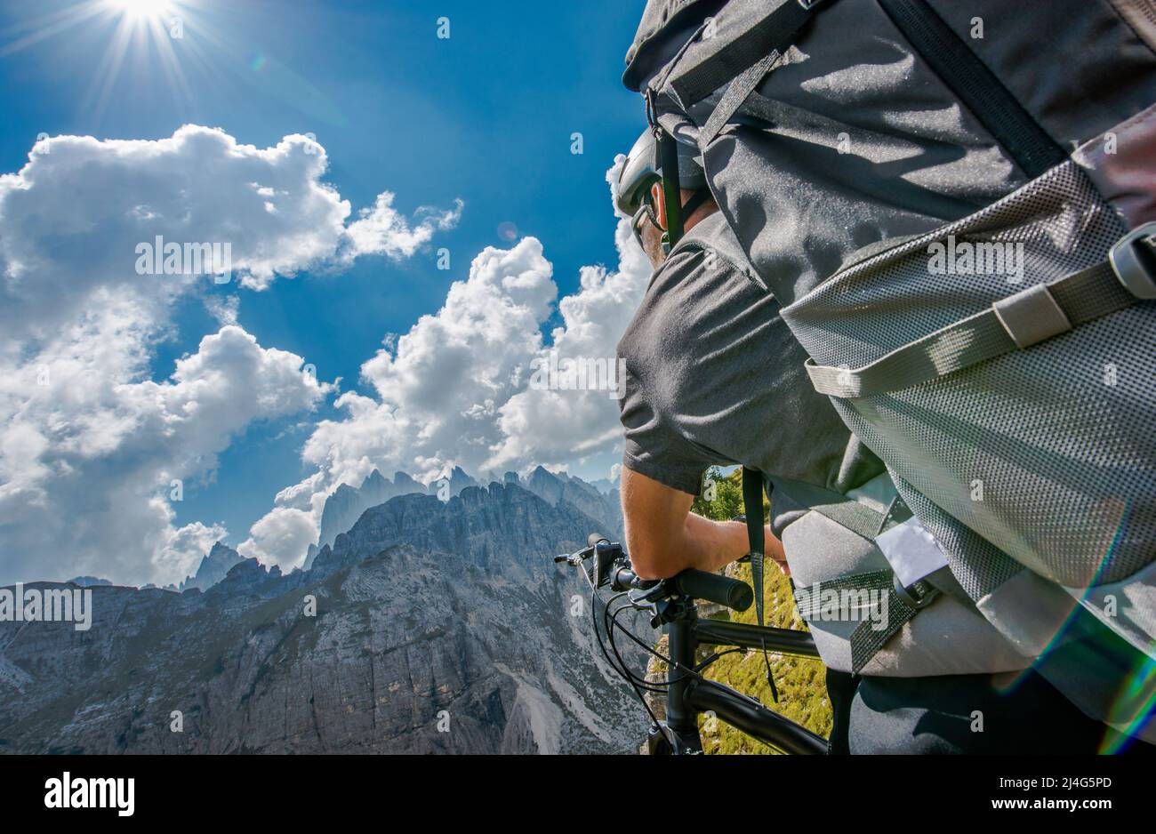 Vélo d'été en montagne avec sac à dos. Les hommes caucasiens sur un sentier de montagne quelque part dans les Dolomites italiens. Banque D'Images