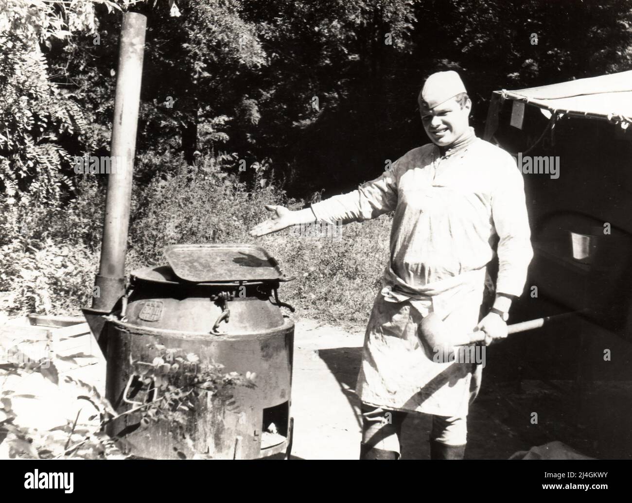 Village de Trekhizbenka, région de Luhansk, URSS - vers 1982 : photo d'un jeune cadet en uniforme militaire en service dans la cuisine de campagne. Banque D'Images