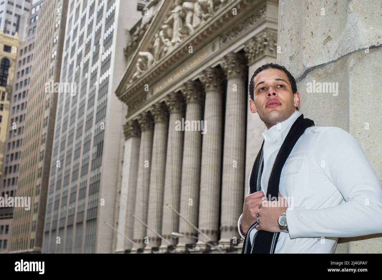 Un jeune étudiant d'université est debout à l'extérieur d'un quartier d'affaires et attend avec impatience. Banque D'Images