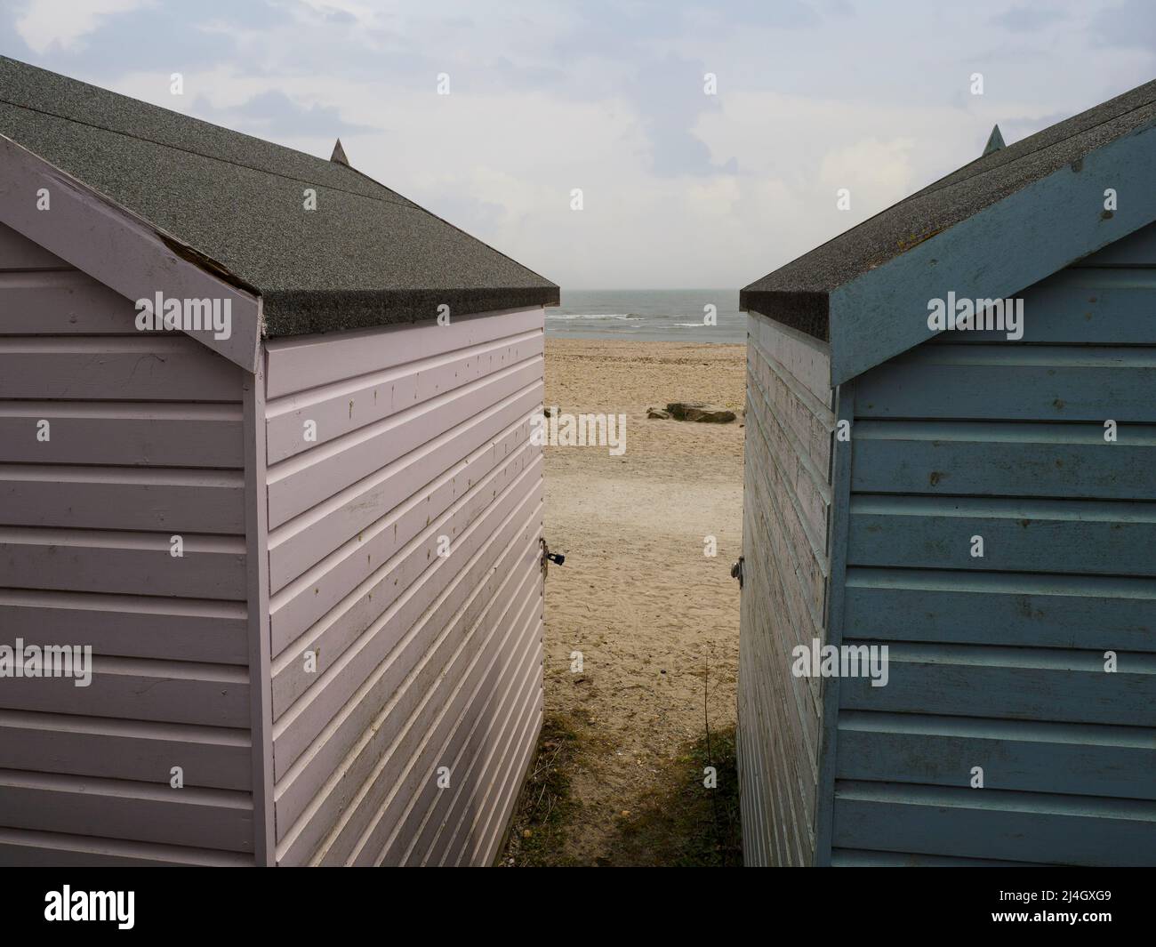 Vue entre deux cabanes de plage d'Avon Beach, Christchurch, Dorset, Royaume-Uni Banque D'Images